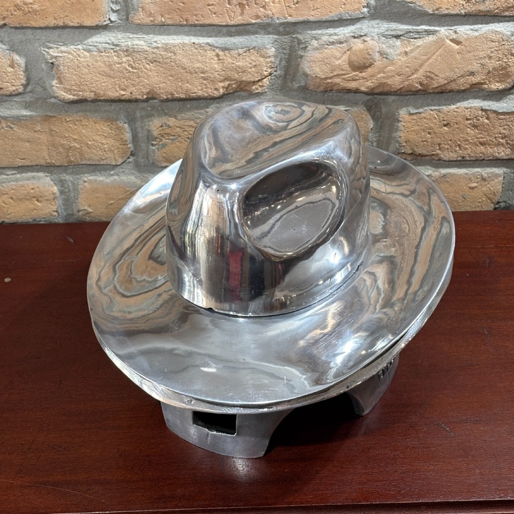 A polished silver aluminium two-piece milliners hat block mould stamped with maker details. View VII