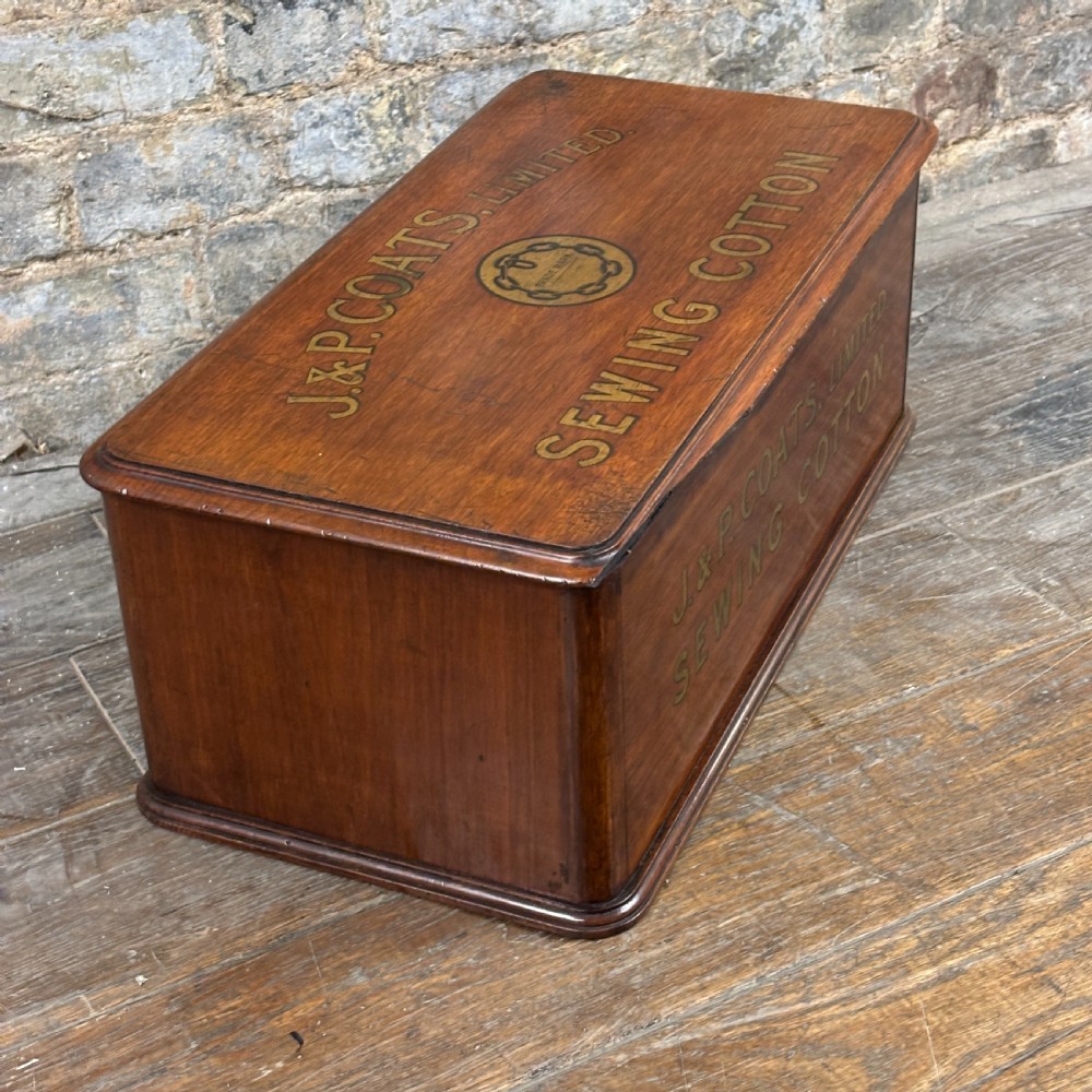 An antique wooden J. & P. Coats countertop drawer unit with stencilled lettering on the drawers and top surface. View V