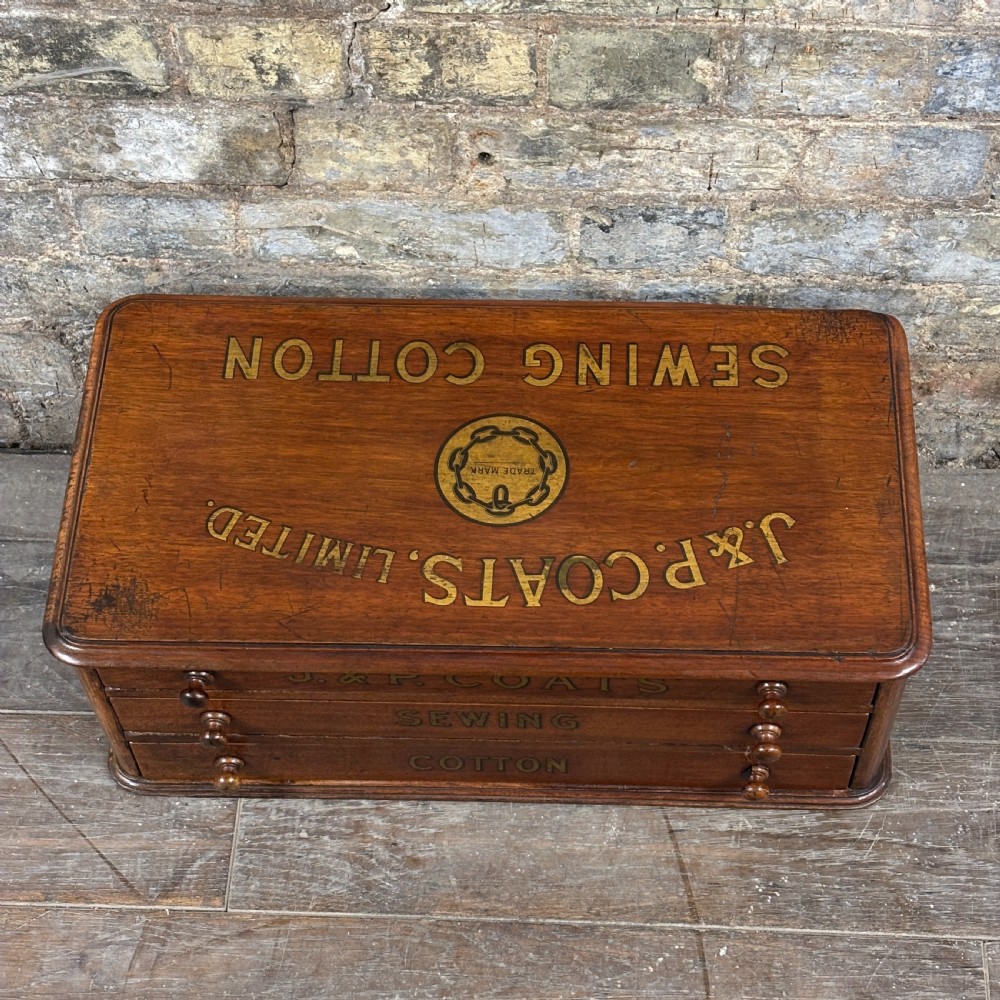 An antique wooden J. & P. Coats countertop drawer unit with stencilled lettering on the drawers and top surface. View VI