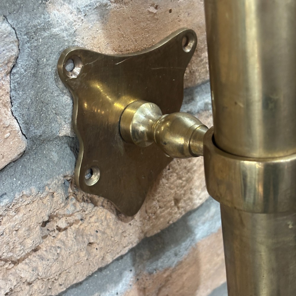 A pair of long, vertical antique brass door pull handles featuring turned urn finials at the top and mounting brackets. View II