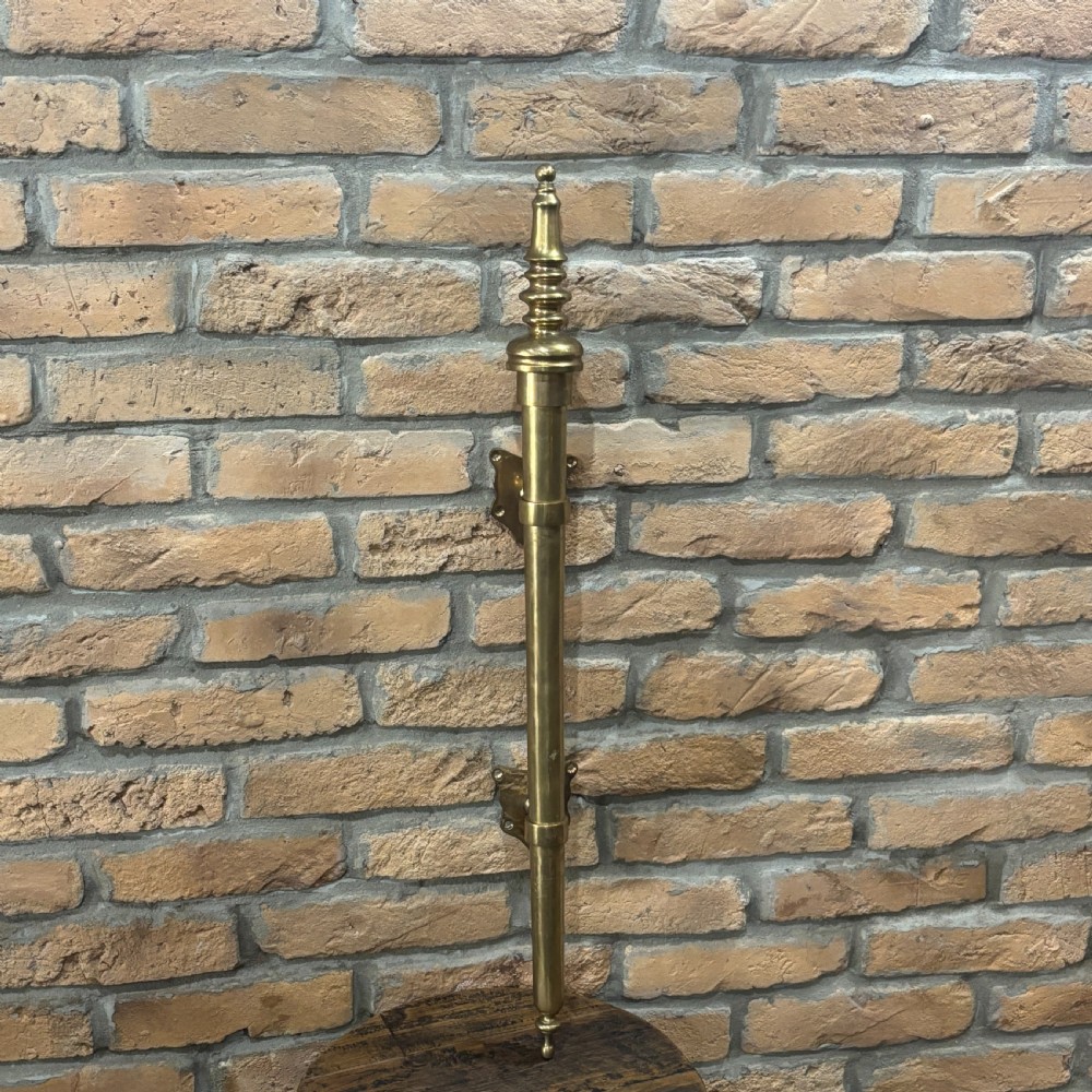A pair of long, vertical antique brass door pull handles featuring turned urn finials at the top and mounting brackets. View IV