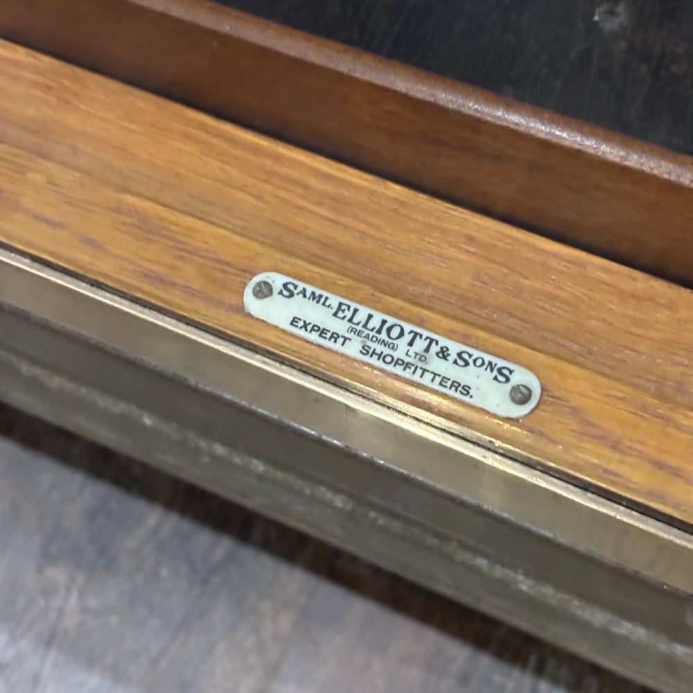 A 1930s brass-framed shop display counter featuring glass side and top panels, tiered interior timber display bins, and timber sliding back doors. View IV
