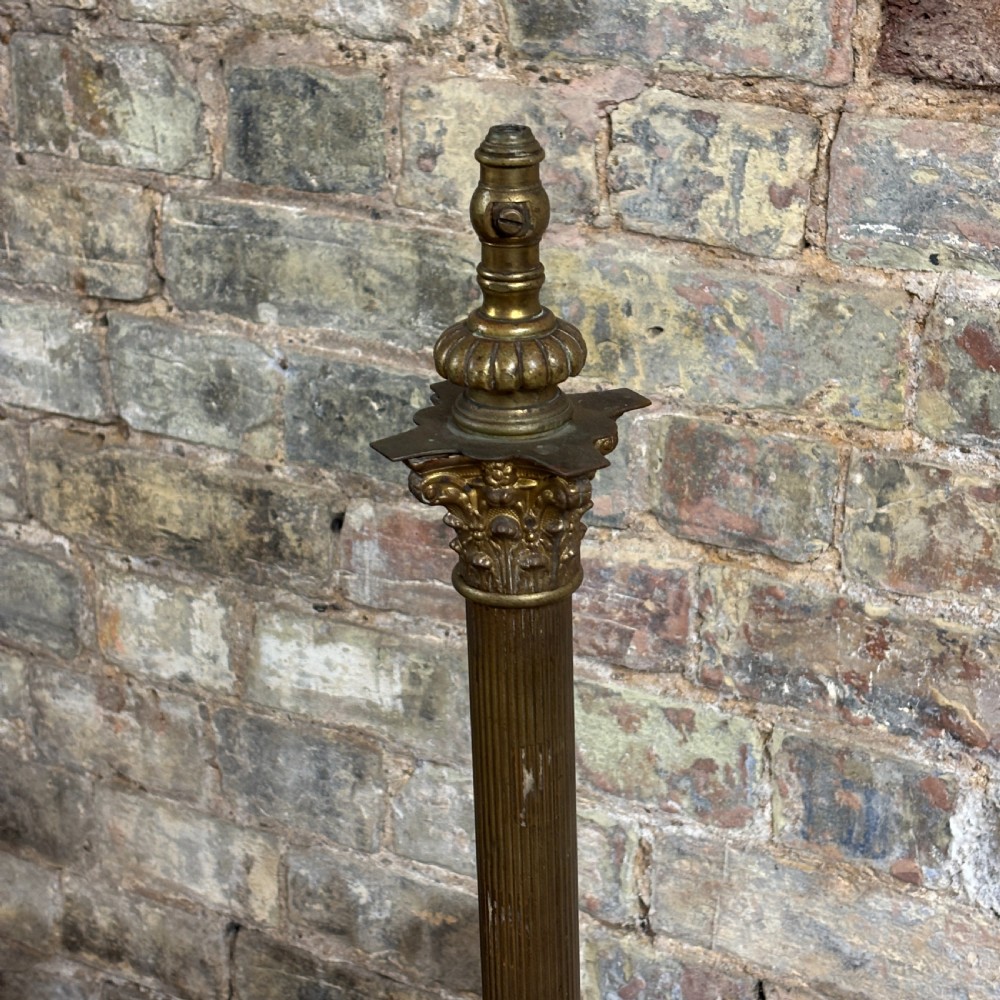 An antique Edwardian brass standard lamp featuring a fluted column, classical capital, and a stepped square base resting on cast claw feet. View IV
