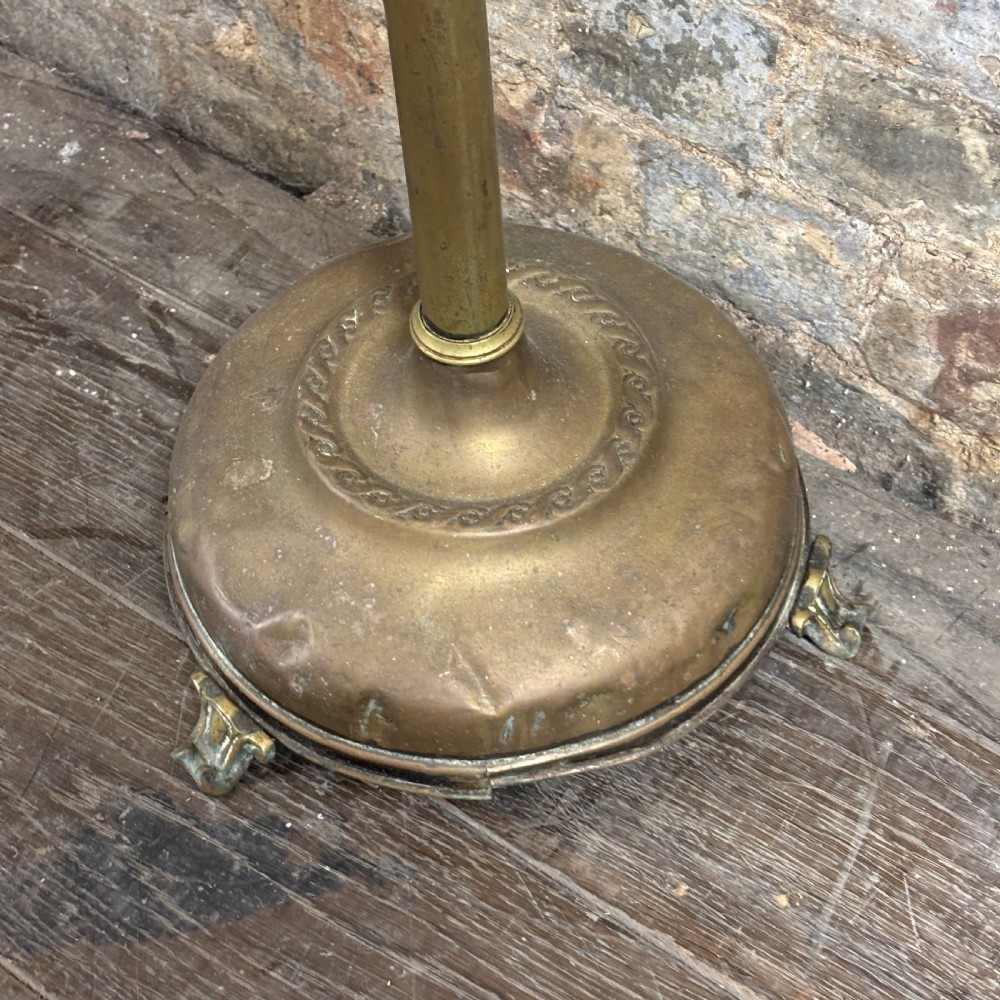 An antique Edwardian turned brass floor lamp stand featuring a weighted domed base on small feet and a slender central column. View II