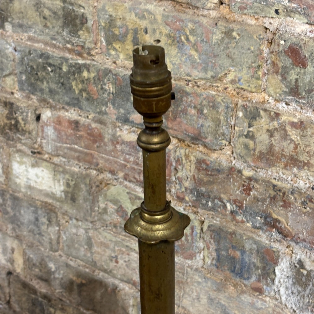 An antique Edwardian turned brass floor lamp stand featuring a weighted domed base on small feet and a slender central column. View III
