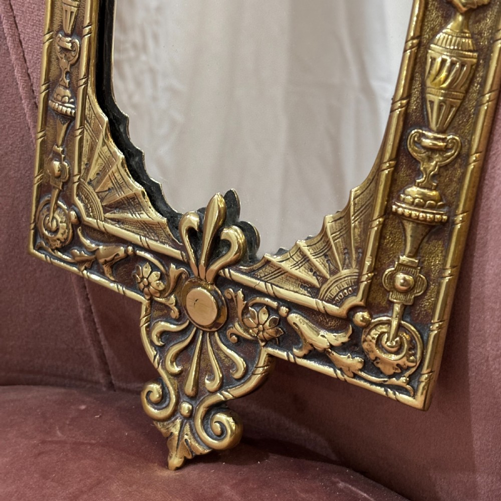 A pair of rectangular brass wall mirrors featuring ornate classical mask crestings, floral garlands, and scrolled detailing. View III