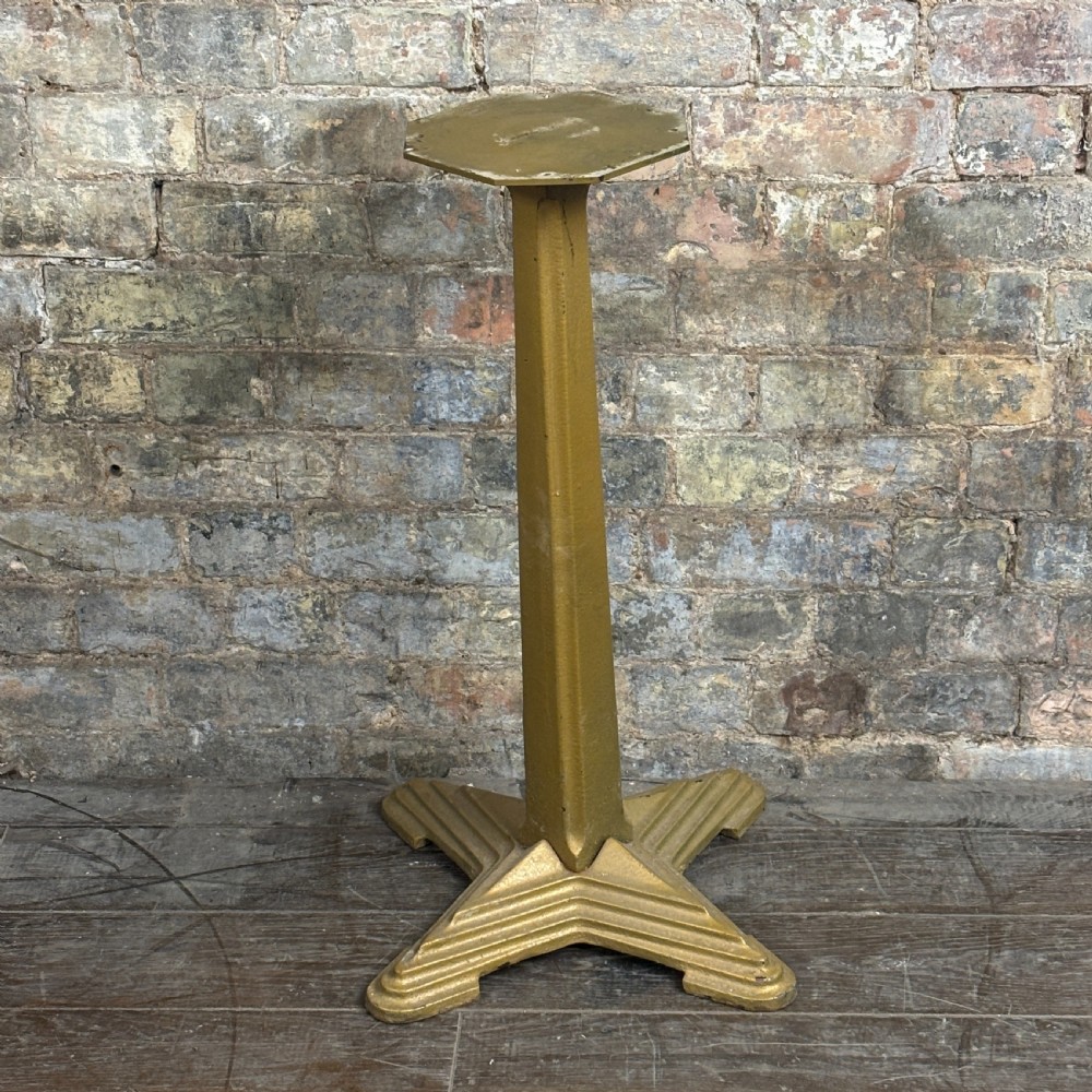 A gold-painted cast iron table base featuring a four-star stepped base, a central tapered column, and an octagonal top mounting plate.