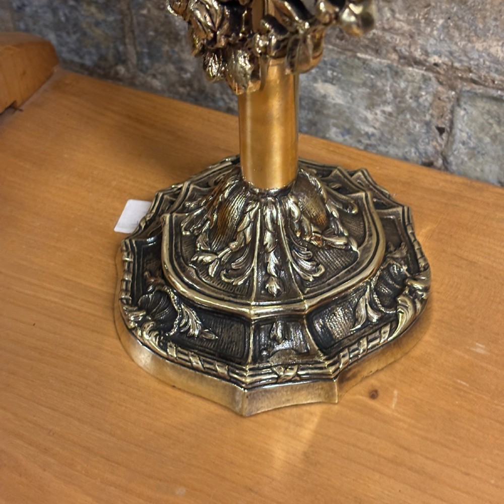 An ornate 1930s cast brass dressing table mirror with detailed floral scrollwork, an oval mirror frame, and a sturdy pedestal base. View II