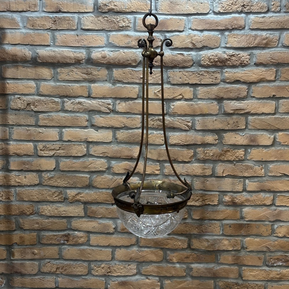 A late Victorian ceiling pendant light featuring a cut glass bowl suspended by three curved bronze rods attached to a central top ring.
