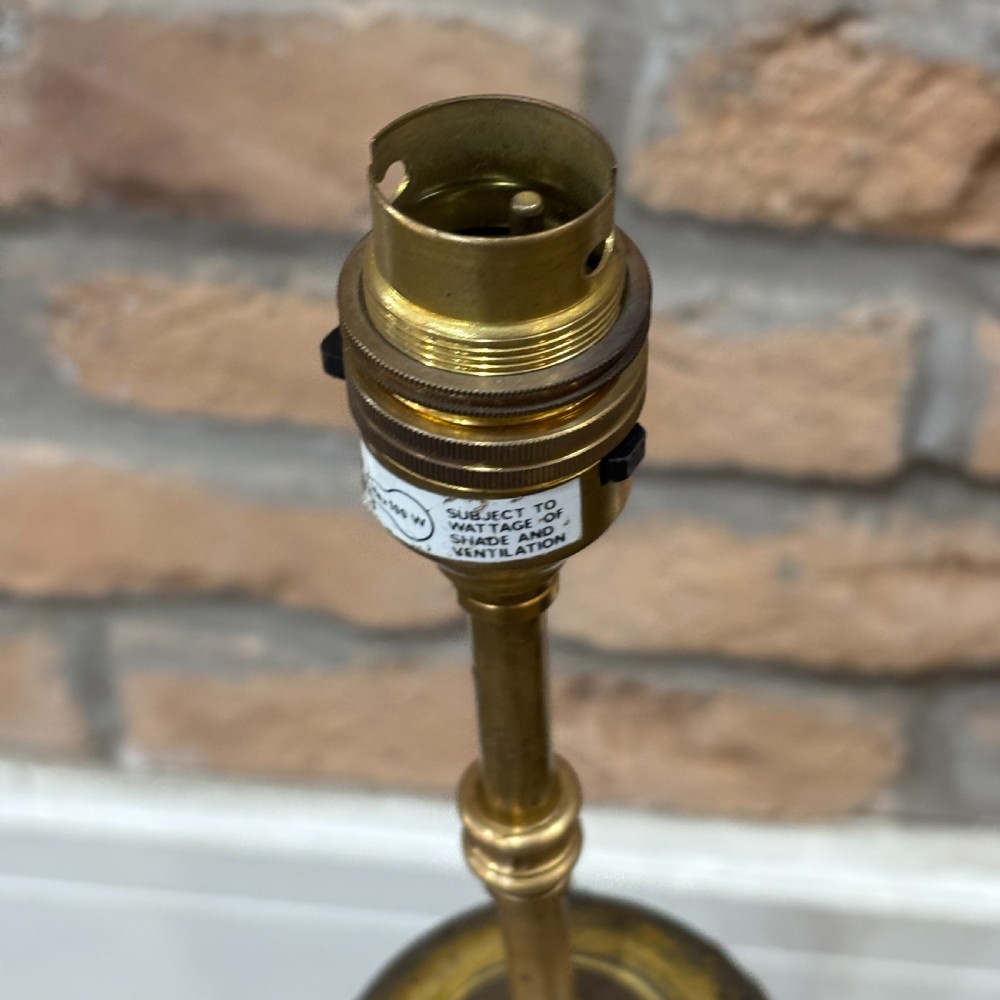 A pair of late Victorian gilt bronze lamp bases featuring ornate scrolling foliate designs, tripod feet, and raised brass light sockets. View IV
