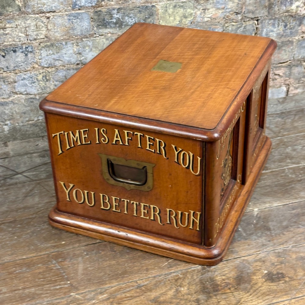 A small 1930s warm brown oak desktop cabinet with two panelled doors featuring hand-painted trade lettering and a rabbit illustration. View VI