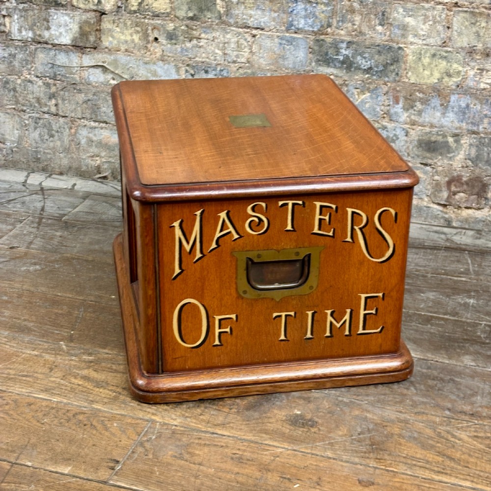 A small 1930s warm brown oak desktop cabinet with two panelled doors featuring hand-painted trade lettering and a rabbit illustration. View VII