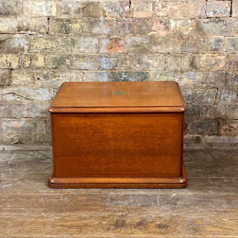 A small 1930s warm brown oak desktop cabinet with two panelled doors featuring hand-painted trade lettering and a rabbit illustration. View VIII