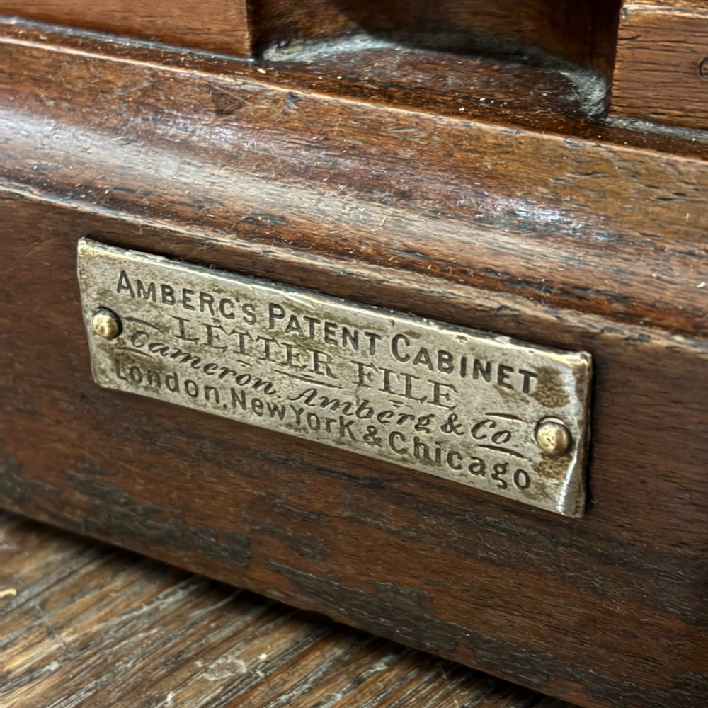 An Edwardian oak Ambergs patent letter filing cabinet featuring three vertical columns of ten small drawers fitted with brass label holders. View V