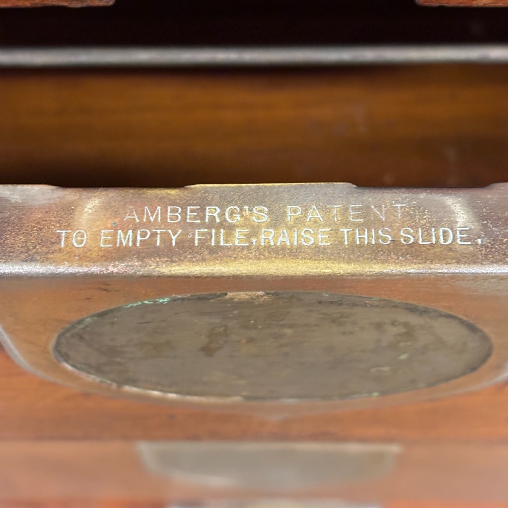 An Edwardian oak Ambergs patent letter filing cabinet featuring three vertical columns of ten small drawers fitted with brass label holders. View VII