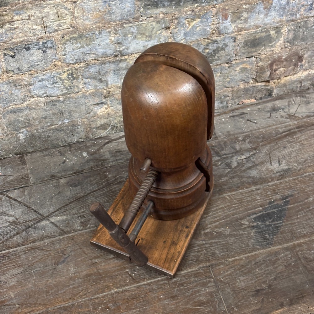 A late 19th-century wooden hat stretcher featuring a split two-part head mounted on a rectangular base with a metal screw-thread mechanism. View II