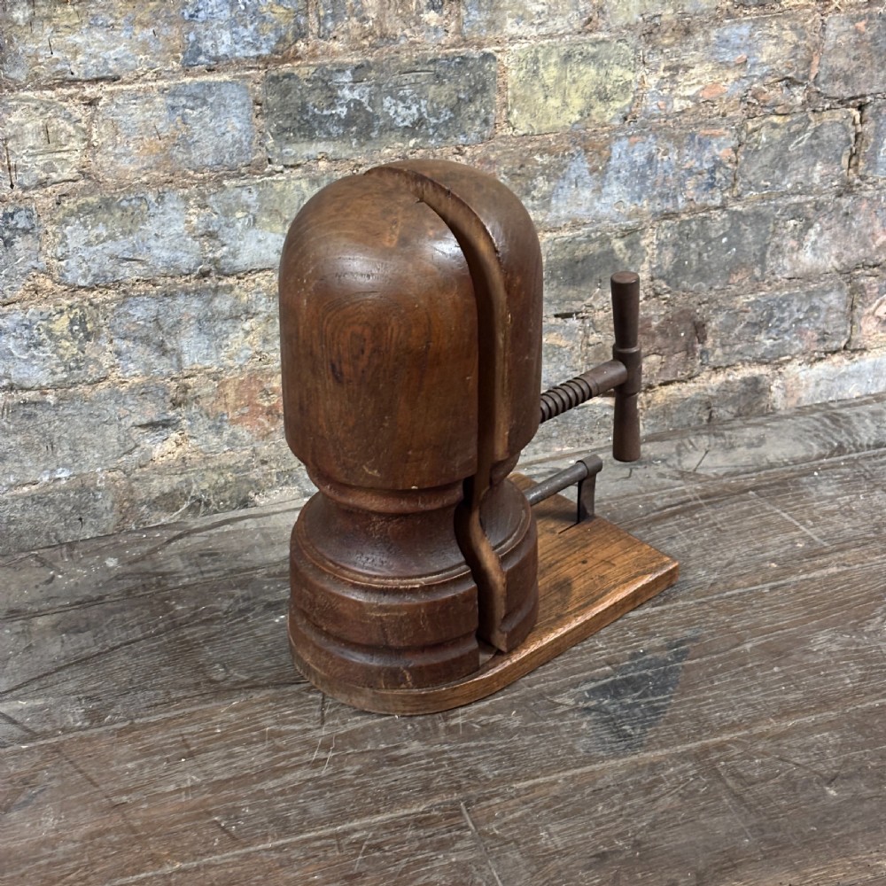 A late 19th-century wooden hat stretcher featuring a split two-part head mounted on a rectangular base with a metal screw-thread mechanism. View IV