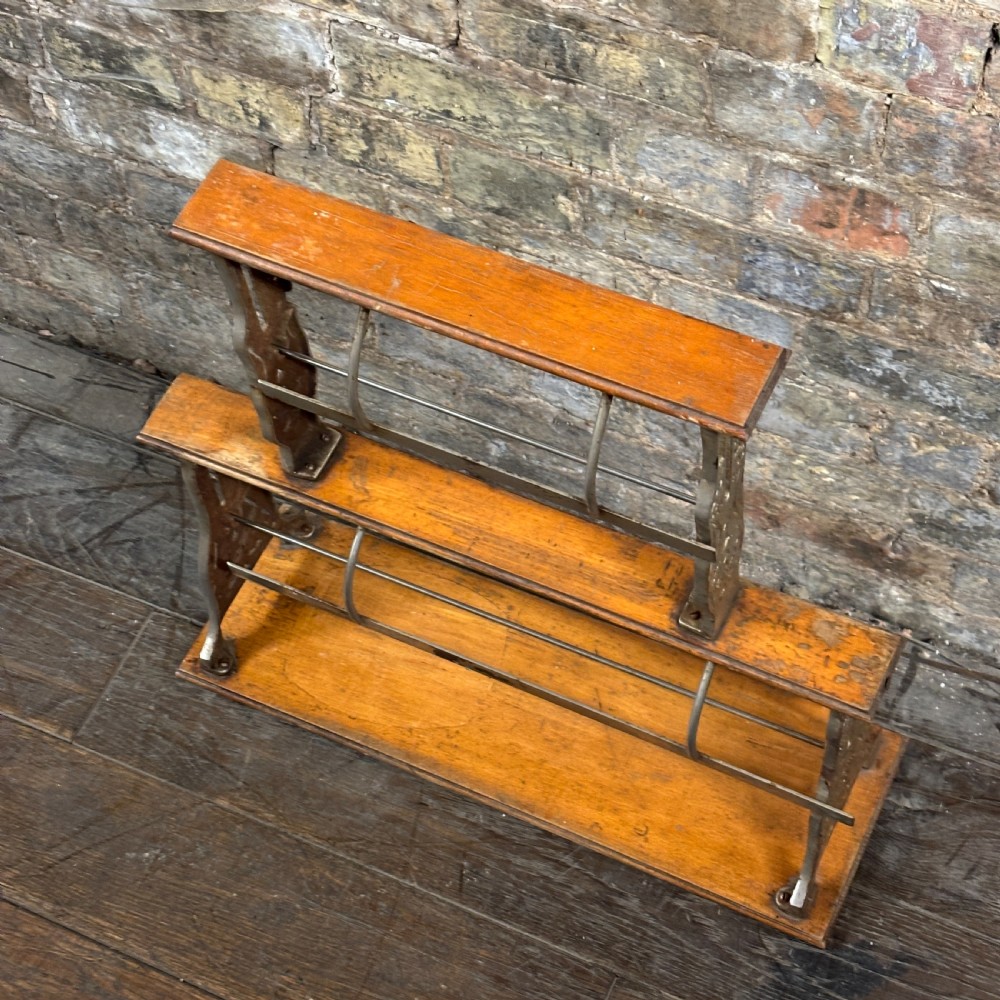A two-tier antique paper roll dispenser featuring warm brown wooden shelves supported by cast metal side brackets and spring bars. View II