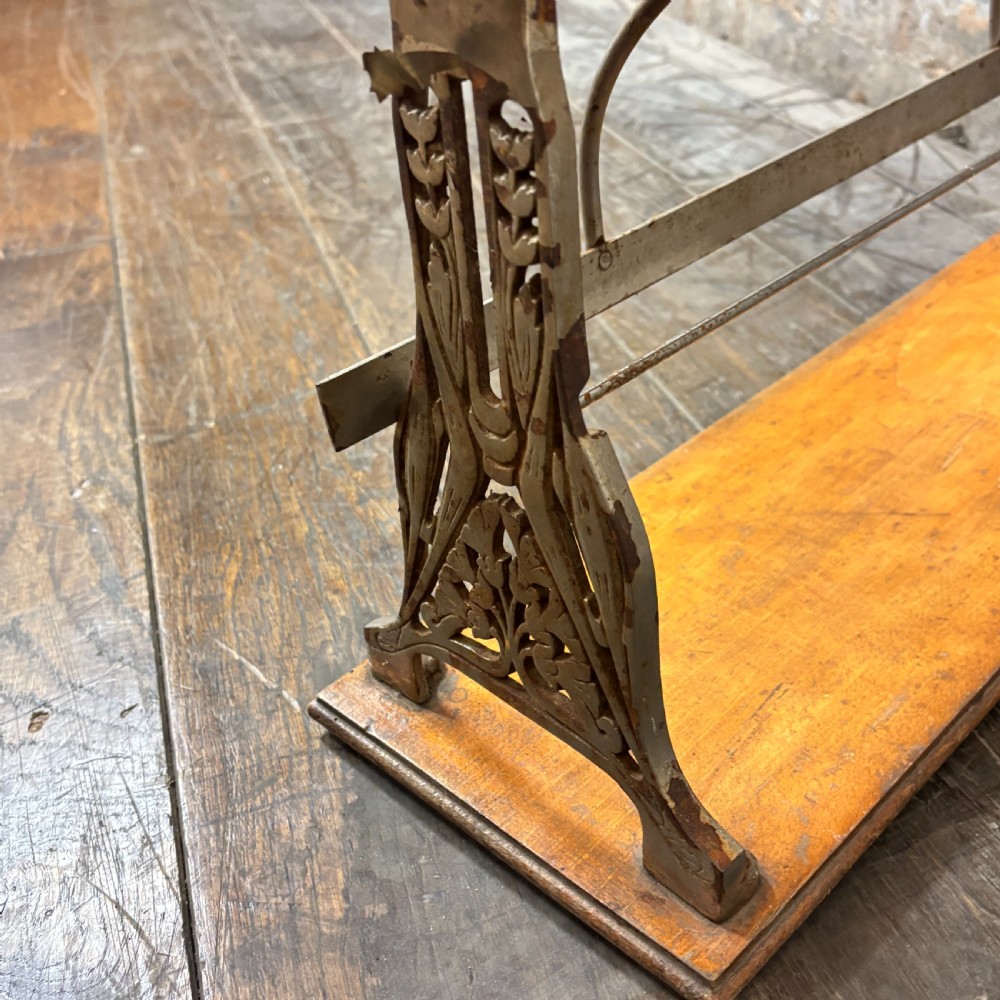 A two-tier antique paper roll dispenser featuring warm brown wooden shelves supported by cast metal side brackets and spring bars. View V