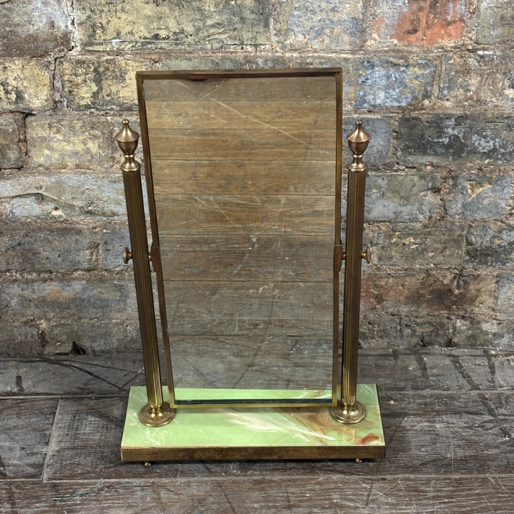 An Art Deco tabletop dressing mirror featuring a rectangular glass panel, fluted brass support columns, and a rectangular green onyx base.