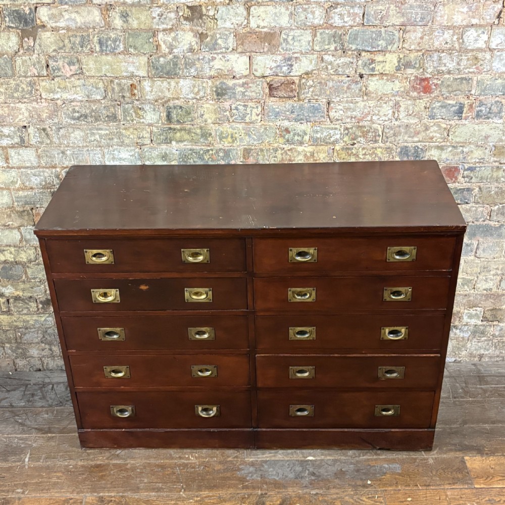 A 1920s mahogany bank of ten drawers featuring inset brass campaign handles and a solid plinth base. View II