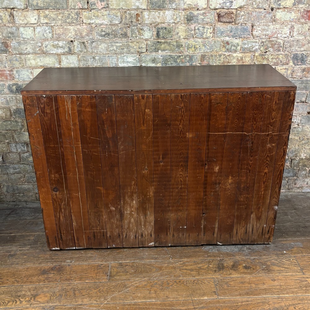 A 1920s mahogany bank of ten drawers featuring inset brass campaign handles and a solid plinth base. View VII