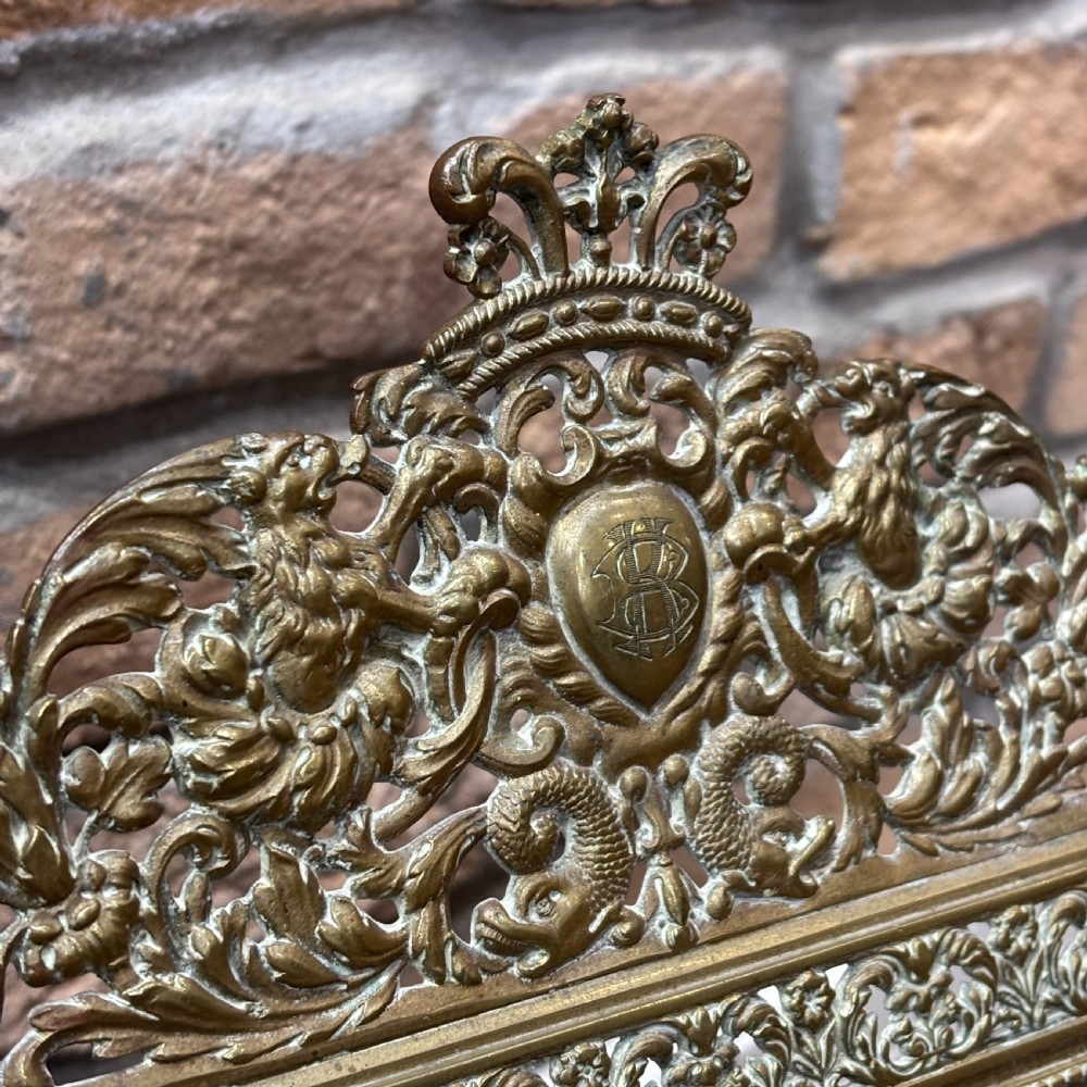 An ornate late nineteenth-century French brass table mirror featuring a crowned crest, relief scrollwork border, and a rectangular bevelled glass plate. View V