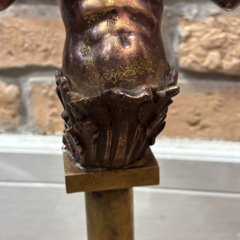 A pair of dark bronze Neoclassical table lamps featuring merman figures supporting twin cornucopia arms on square bases. View V