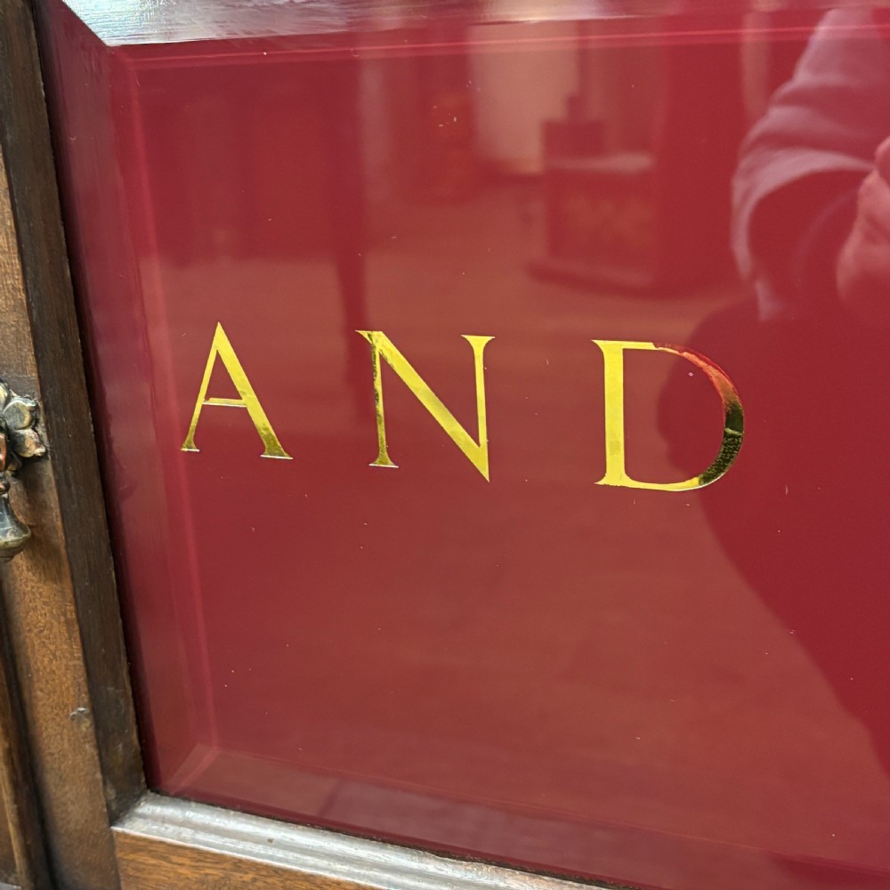 An early 20th-century mahogany office cabinet featuring four maroon panels with gold hand-lettering reading Farrer and Co Barristers Solicitors. View III