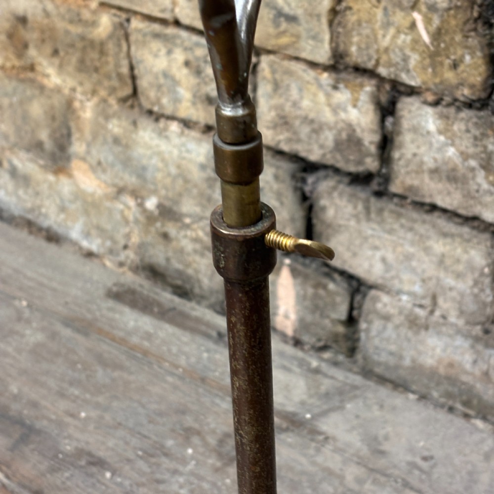 An early 20th-century brass drapers display stand featuring a wire bust frame on an adjustable central column with a heavy fluted cast iron base. View IV