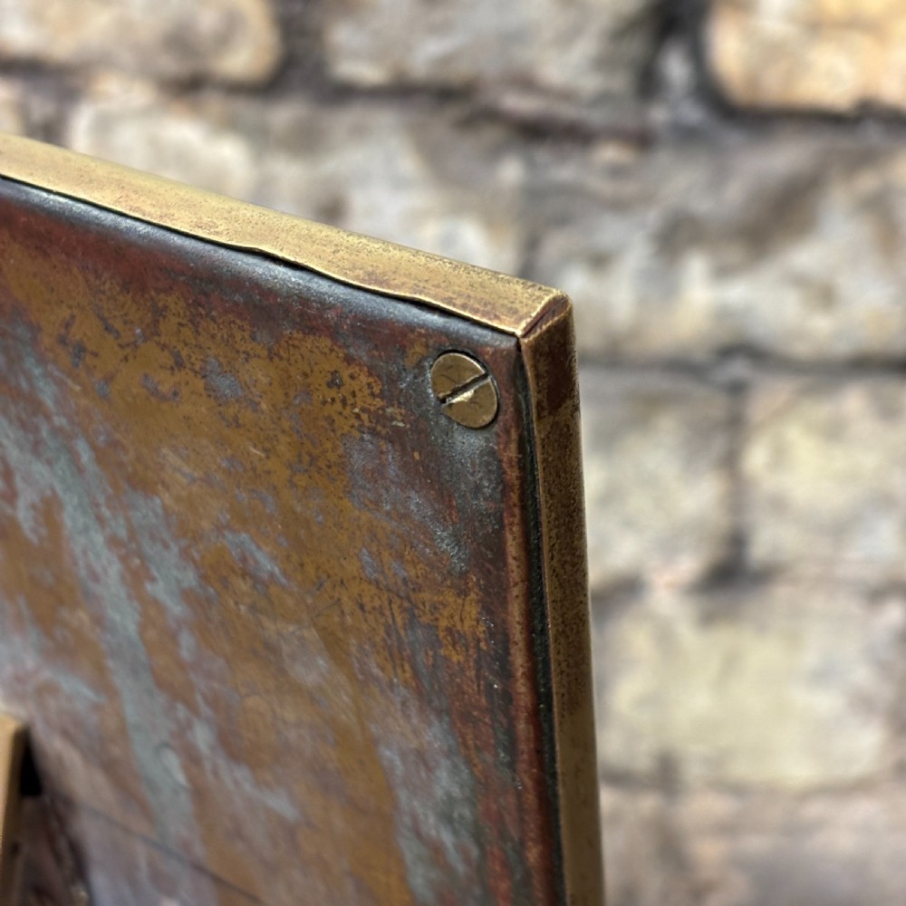 A rectangular Edwardian dressing table mirror with an embossed brass frame featuring fruit motifs surrounding bevelled mirror glass. View VI
