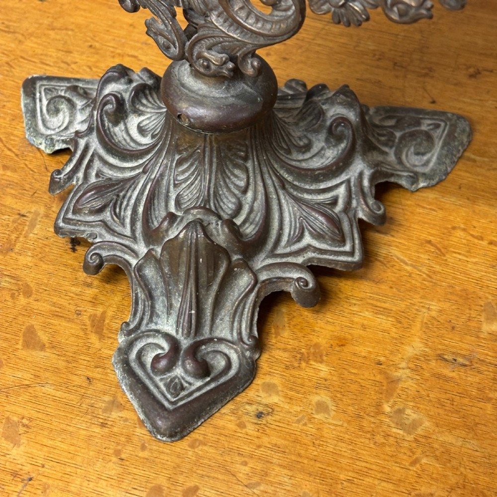 A late Victorian cast bronze dressing table mirror featuring an oval glass frame adorned with intricate floral scrollwork set upon an ornate pedestal base. View V