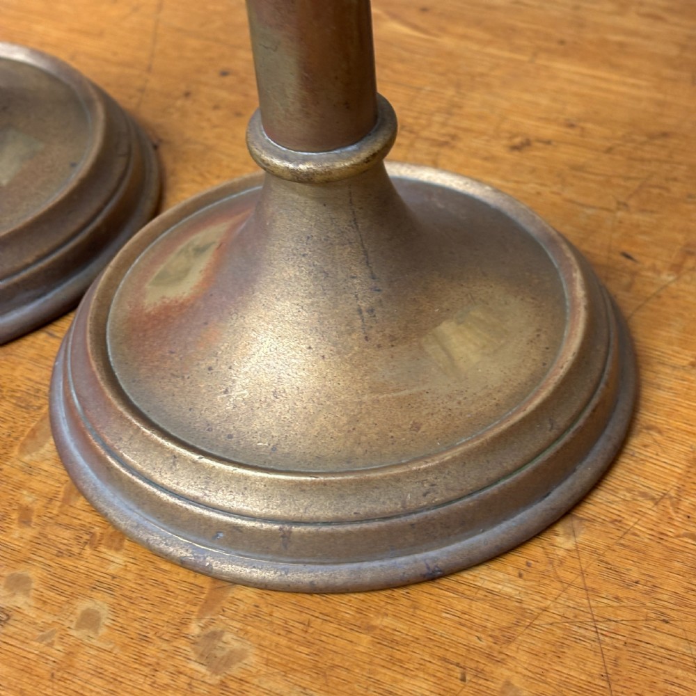A pair of early 20th-century brass candlestick table lamps with scalloped drip trays, turned stems, and circular stepped bases. View III