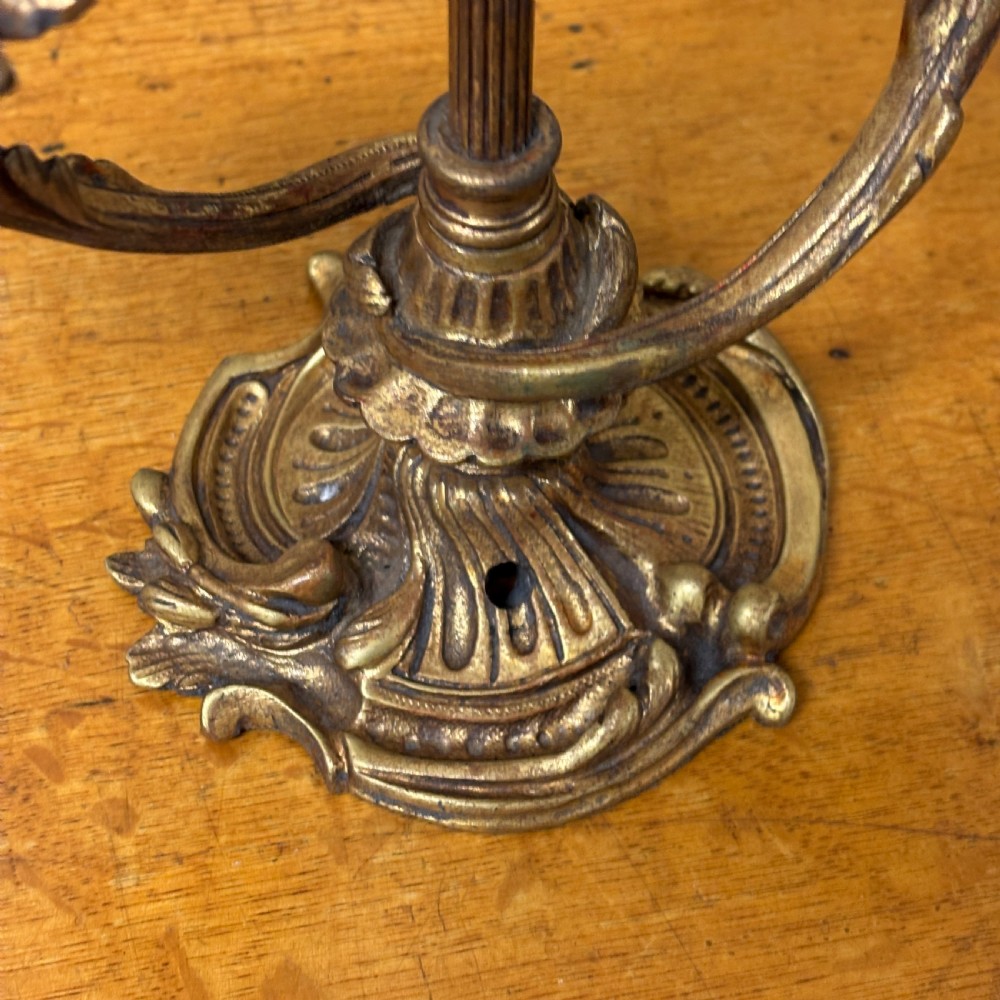An antique cast brass candelabra table lamp featuring a scrolled base, twin candle sconces, two electrical fittings, and a finial top. View II