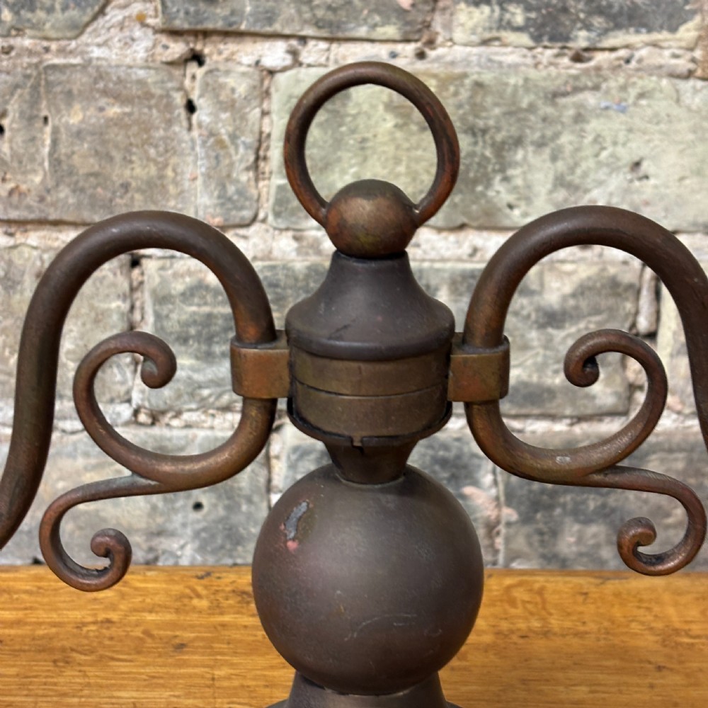 An early 20th-century patinated brass two-arm candelabra table lamp featuring curved scroll arms, faux candle sleeves, and a stepped circular base. View II