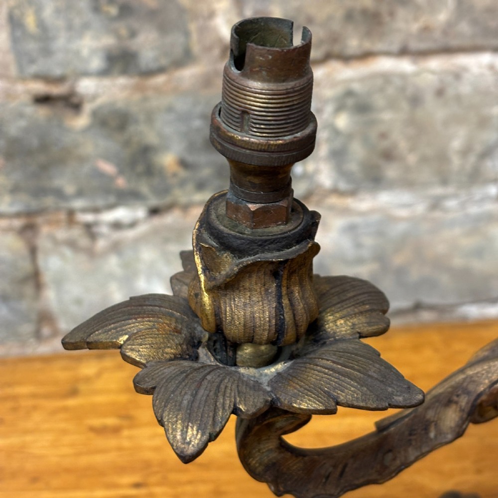 A two-arm gilt brass table lamp base featuring sculpted leaf motifs, curved organic branches, and a broad scrolling base. View III