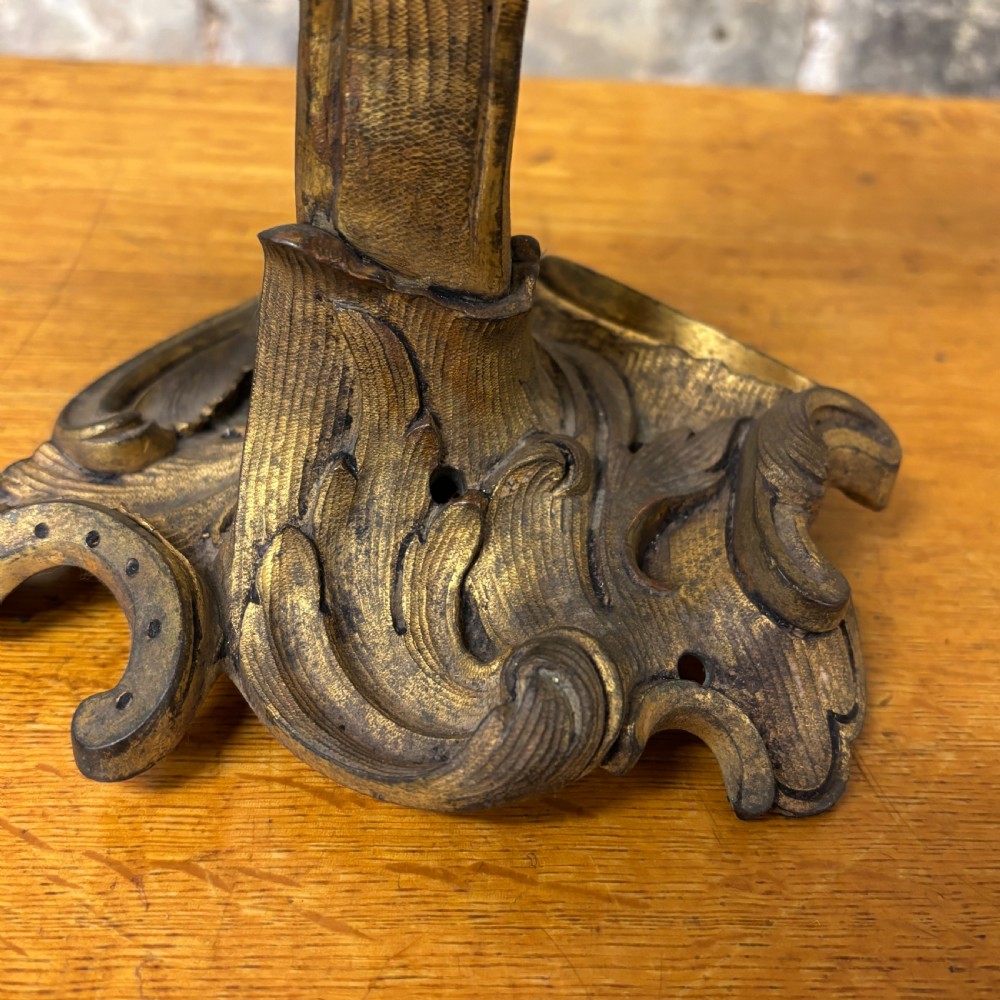 A two-arm gilt brass table lamp base featuring sculpted leaf motifs, curved organic branches, and a broad scrolling base. View VI