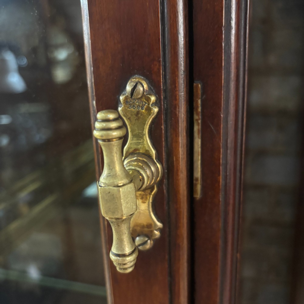 A tall Edwardian mahogany display cabinet featuring full-length glass side and front panels, glass shelves, and a moulded top cornice. View II