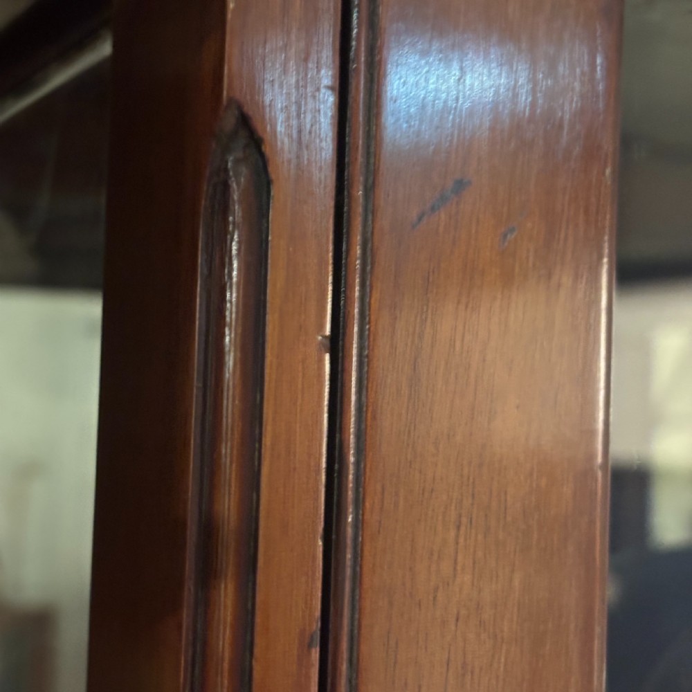 A tall Edwardian mahogany display cabinet featuring full-length glass side and front panels, glass shelves, and a moulded top cornice. View III
