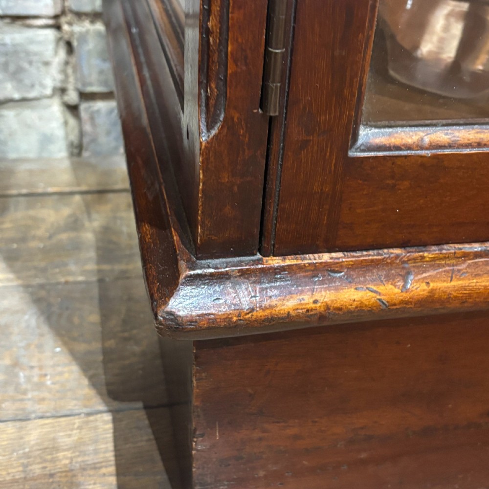 A tall Edwardian mahogany display cabinet featuring full-length glass side and front panels, glass shelves, and a moulded top cornice. View IV