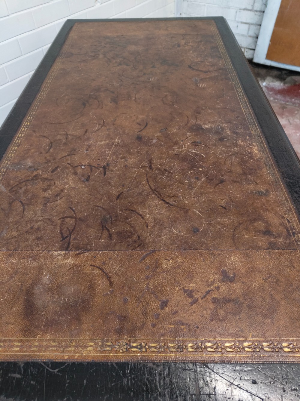 A Victorian Aesthetic Movement ebonised writing table featuring a brown leather inset top, fluted legs with gilt detailing, and brass castors. View XVIII