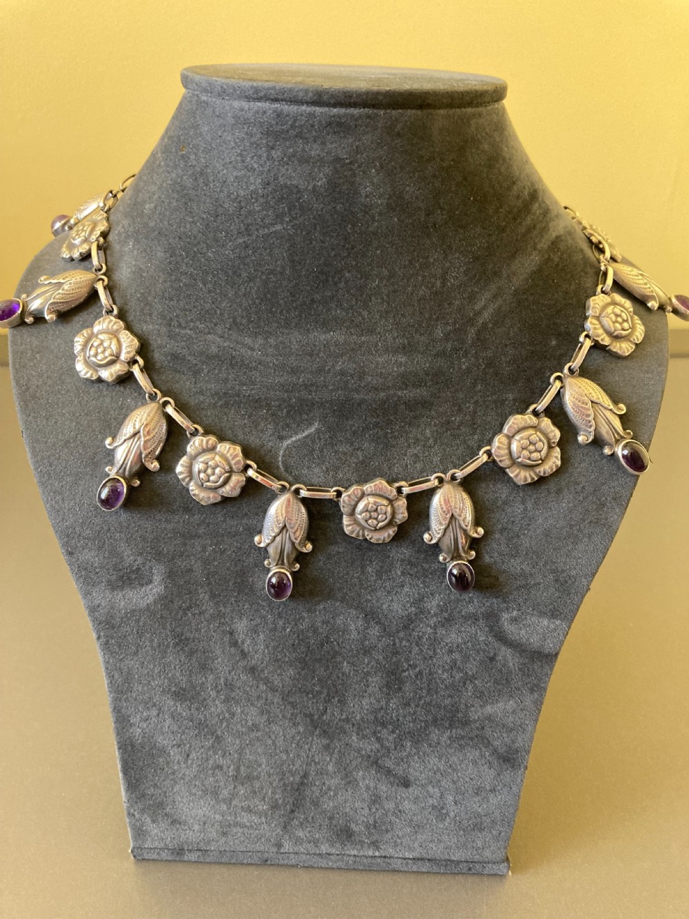 A Danish sterling silver Art Nouveau necklace featuring sculpted floral links and dangling cabochon amethyst gemstones. View IV
