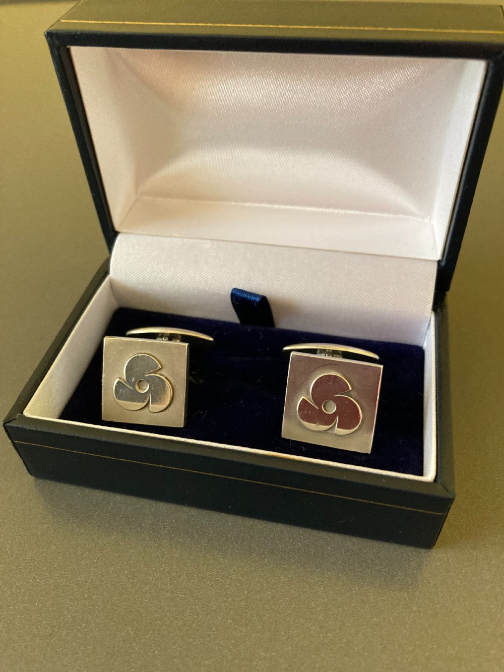 A pair of square Danish silver cufflinks featuring an abstract geometric pinwheel design, displayed in a dark hinged presentation box.