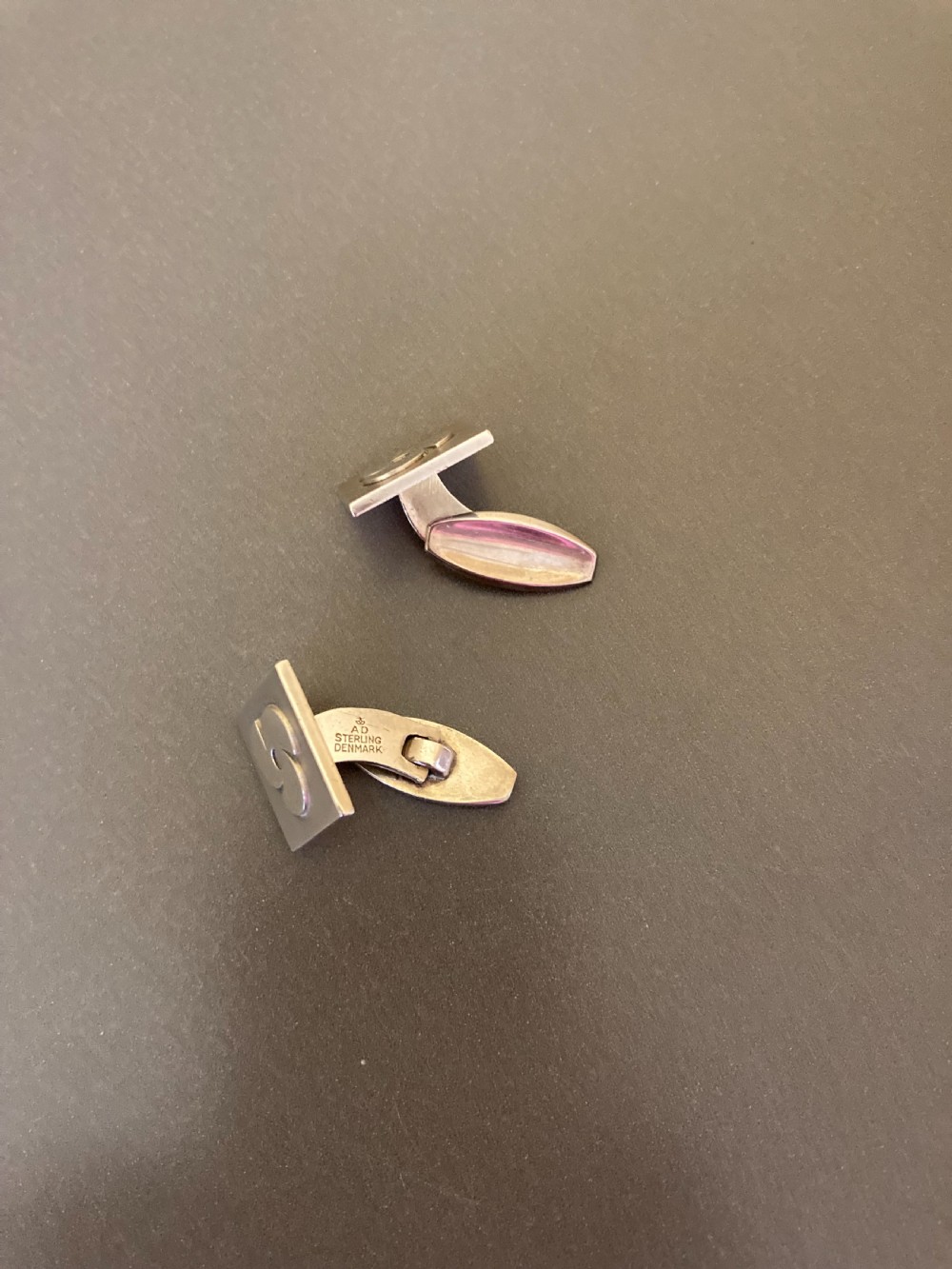 A pair of square Danish silver cufflinks featuring an abstract geometric pinwheel design, displayed in a dark hinged presentation box. View IV