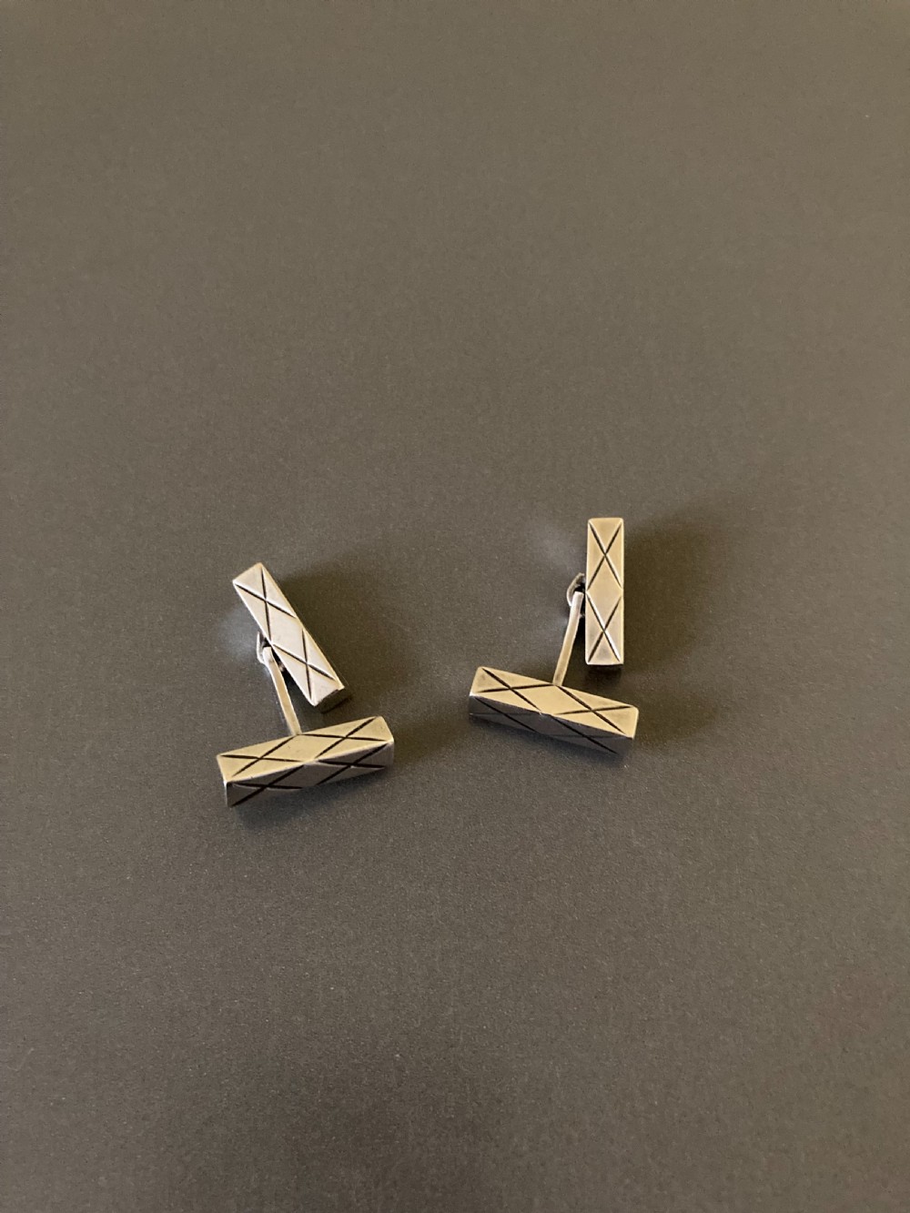 A pair of rectangular mid-century Danish silver cufflinks featuring engraved geometric line patterns. View V