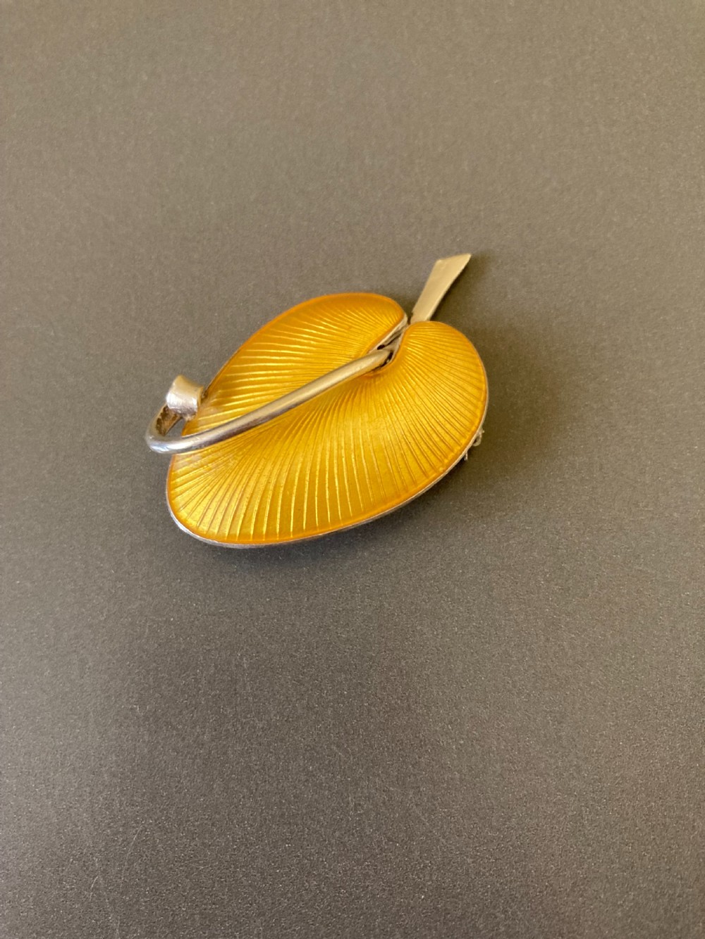 A yellow guilloche enamel leaf brooch set in sterling silver, featuring a stem and curved vein detail. View II