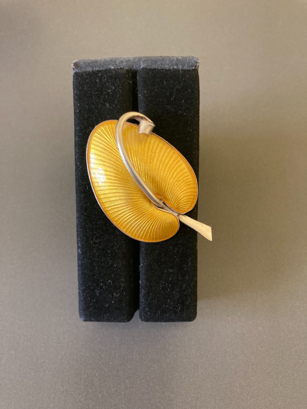 A yellow guilloche enamel leaf brooch set in sterling silver, featuring a stem and curved vein detail. View III