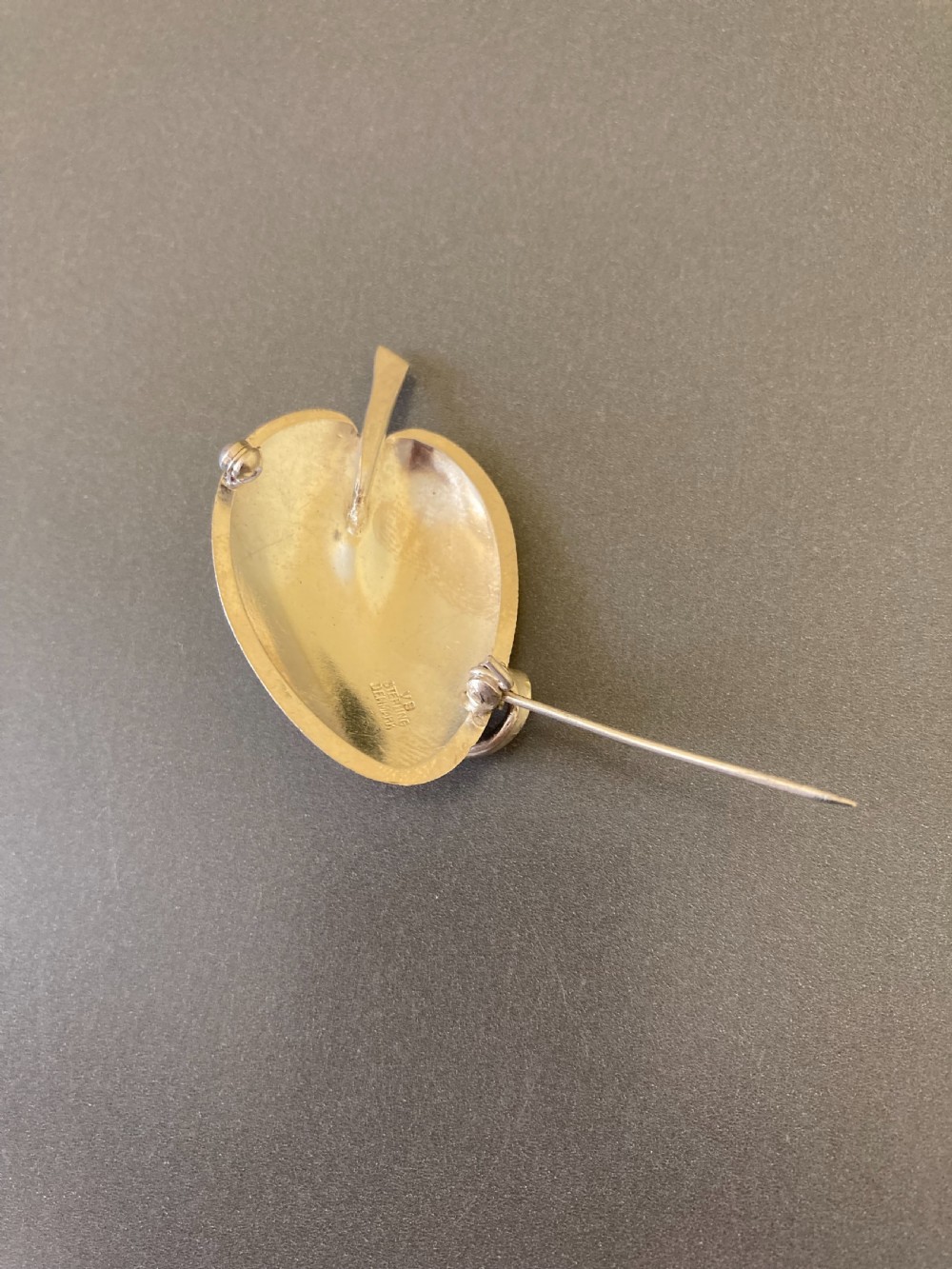 A yellow guilloche enamel leaf brooch set in sterling silver, featuring a stem and curved vein detail. View V
