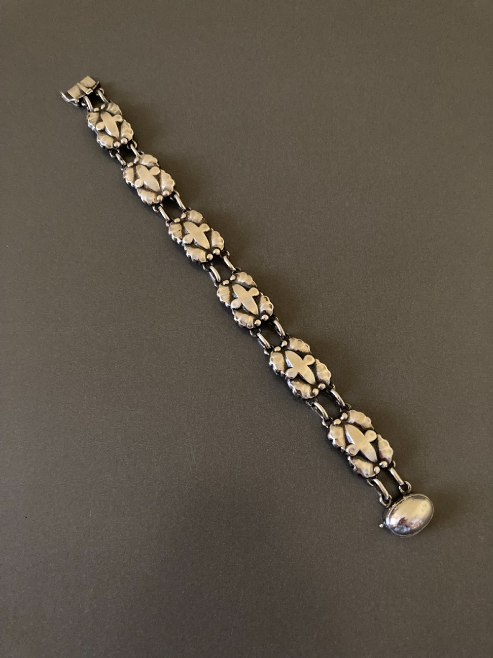 A vintage Georg Jensen sterling silver link bracelet featuring repeating organic floral motifs and a secure clasp.