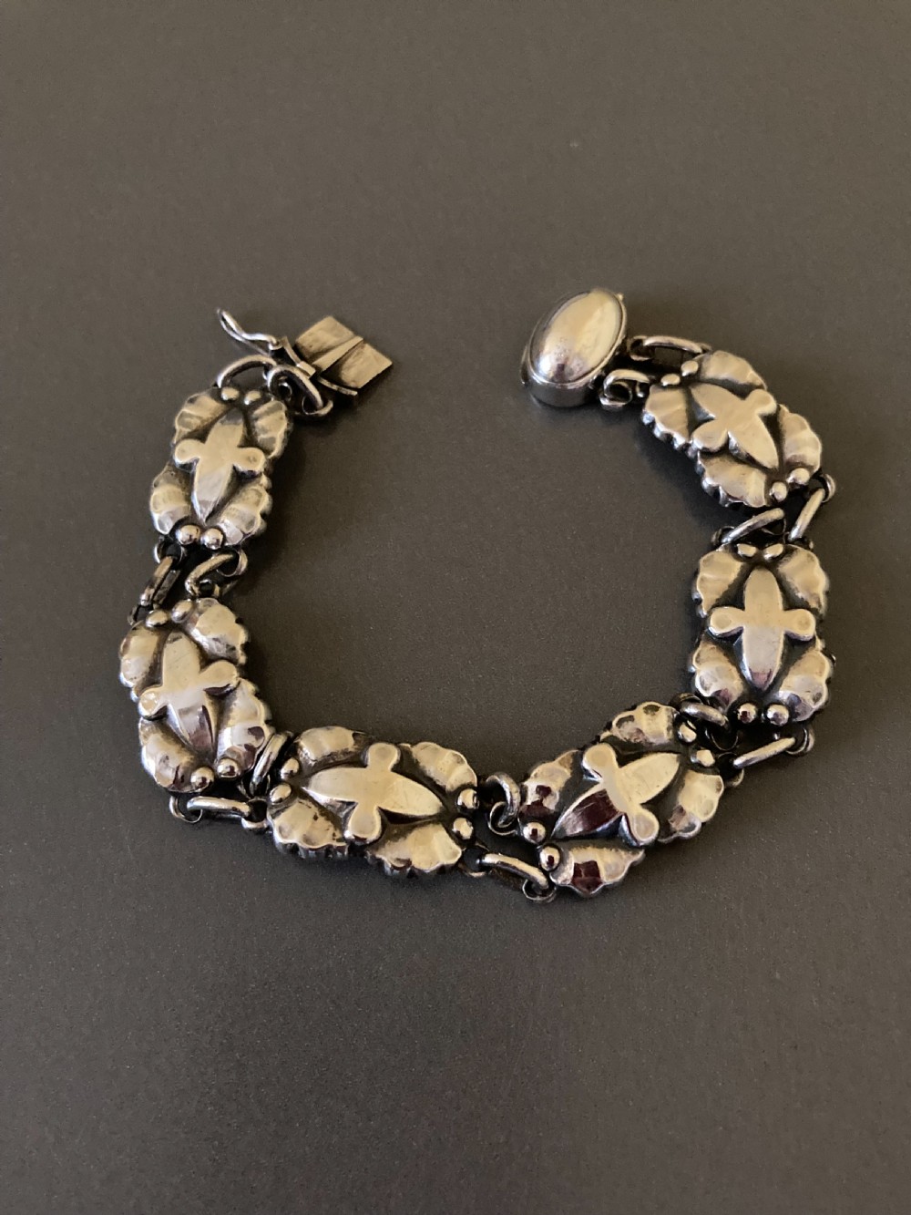 A vintage Georg Jensen sterling silver link bracelet featuring repeating organic floral motifs and a secure clasp. View III